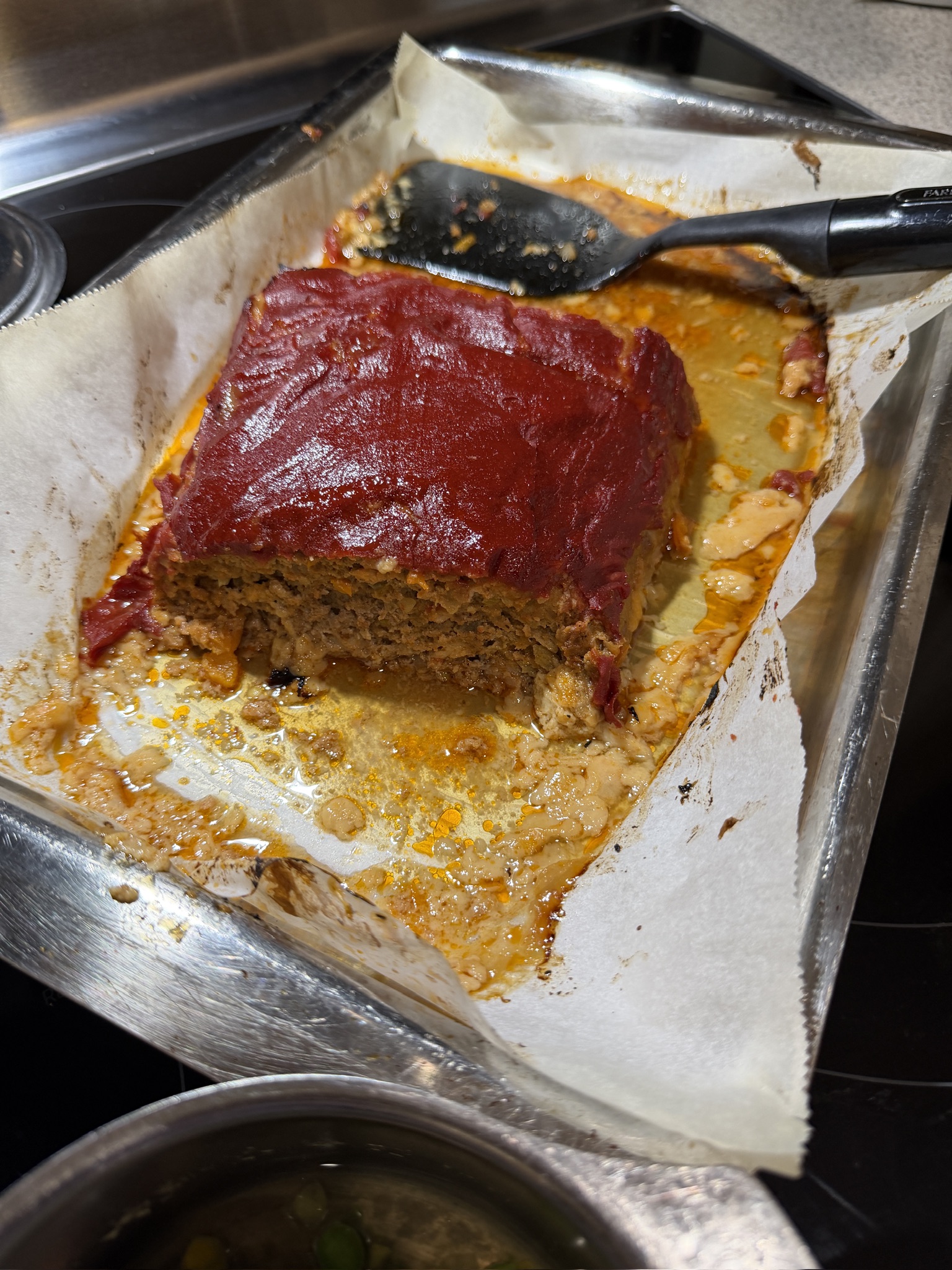 Cajun meatloaf in its pan with a rich tomato topping