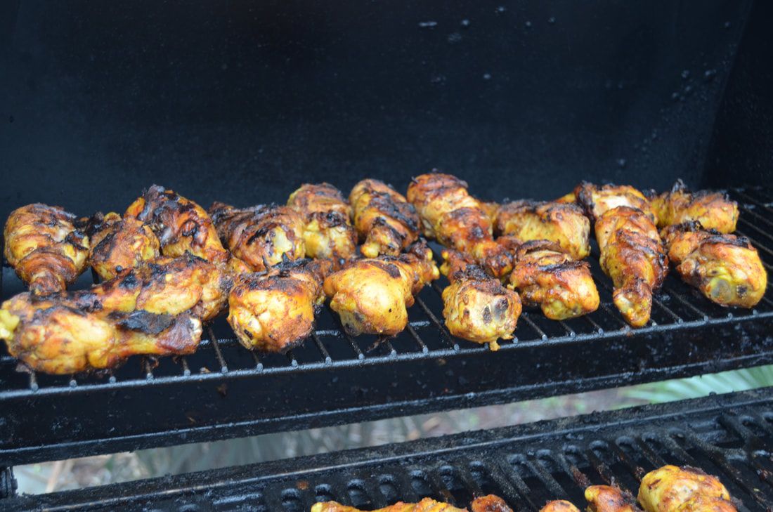 Jamaican jerk chicken grilling over open heat