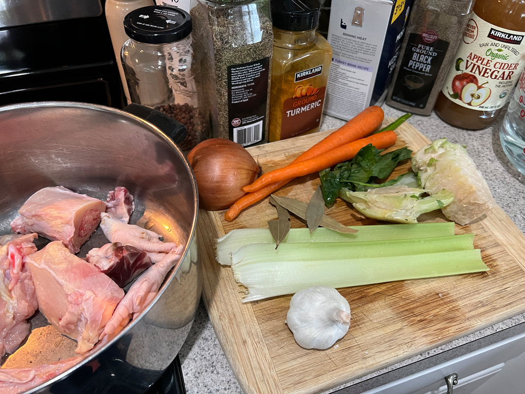 Homemade golden bone broth with vegetables and herbs